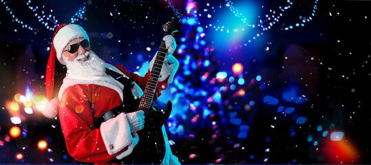 Santa Claus playing the electric guitar in a nightclub at a Christmas and New Year party or...