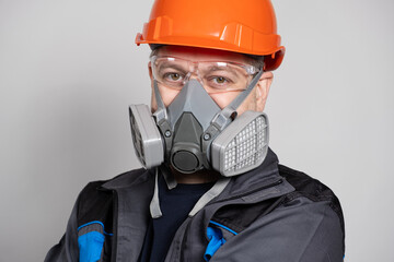 A man wearing a helmet, respirator and goggles on a white background