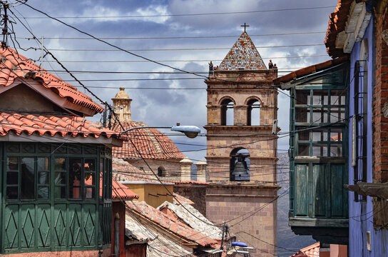 High view of the ancient bell tower of San Francisco church between colonial balconies and rooftops in Potosi, Bolivia. Religious architecture. Southamerica