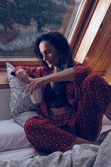 Serene woman chilling in bedroom in cottage - obrazy, fototapety, plakaty