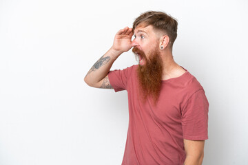 Redhead man with long beard isolated on white background with surprise expression while looking side