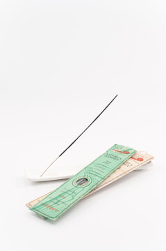 immagine primo piano con bastoncino di incenso profumato e confezione su supporto in ceramica bianco, sfondo superficie bianca