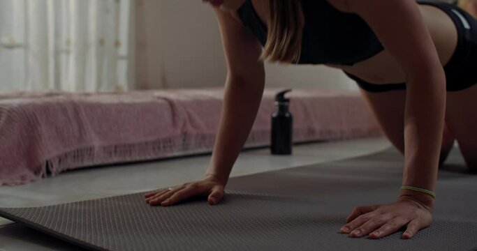 Body care of a girl doing fitness classes at home on a mat. A woman exercises, works out, and goes on a diet for an athletic, athletic, sexy body. High quality 4k footage
