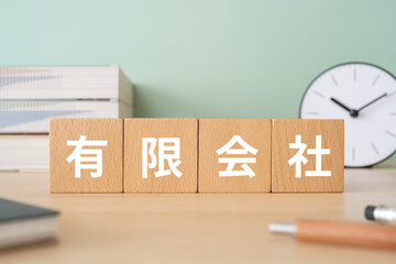 有限会社と書かれたブロックが置かれたデスク