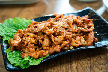 Delicious Korean cuisine jeyuk bokkeum, stir-fried pork in a plate for serving dish.