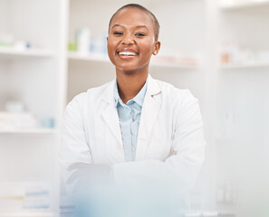 Crossed arms, smile and portrait of black woman pharmacist working in chemist for medication...