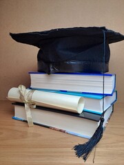 Pergamena di laurea honoris causa. Libri e pergamena impilati con pergamena arrotolata.