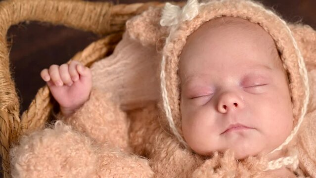 Sleeping newborn beautiful cute baby girl or boy before photo session during first week of life. 4k slow motion raw video. Happy Family concept. Small baby at wicker basket sleep in warm lamb costume