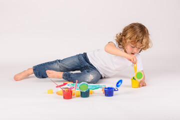 Boy with colorful paints in studio