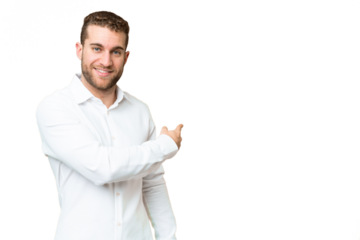 Young handsome blonde man over isolated chroma key background pointing back