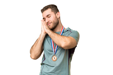 Young handsome blonde man with medals over isolated chroma key background making sleep gesture in dorable expression