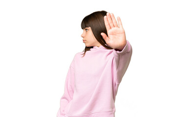 Little girl over isolated green chroma key background making stop gesture and disappointed