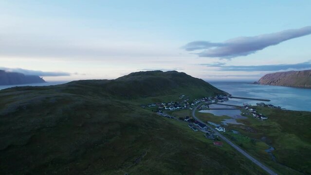 Aerial shot of a fishing village with the sunset and mountains in the background, Skarsvag, Norway