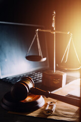 law legal technology concept. judge gavel on computer with scales of justice on desk of lawyer.