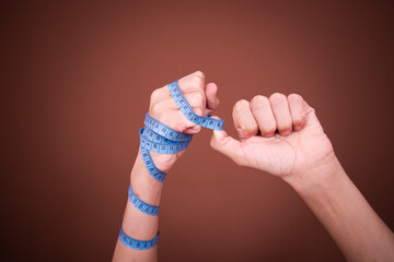Diet and healthy lifestyle. A young guy with his hands tied with tape.