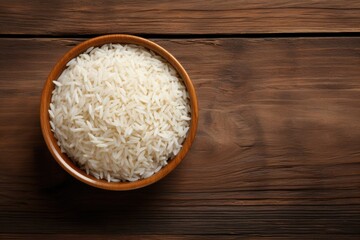 Bowl of rice on wooden table top. Overhead view.