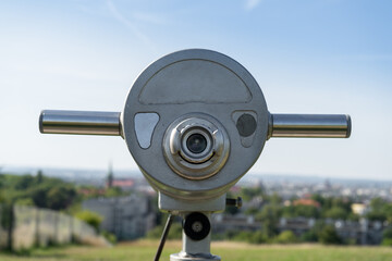 Binocular tower viewer in public tourist viewing spot. Stationary binoculars or telescope on observation viewpoint. Touristic attraction scope. Scenic view of city, lookout point, panorama overlook.