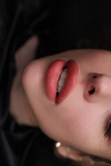 Lips after the permanent makeup procedure, the model parted her lips smiling beautifully. Delicate...