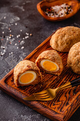 Traditional Scotch Eggs on a wooden board.