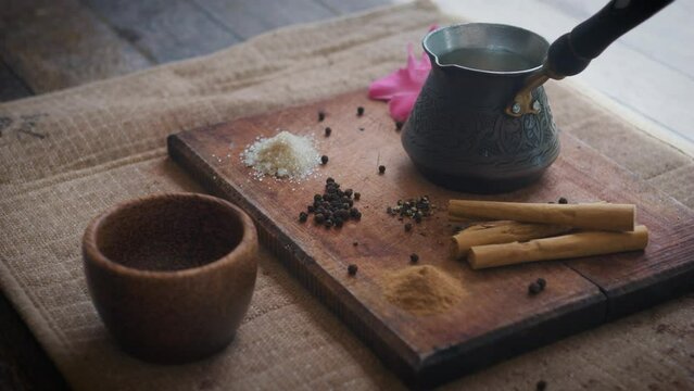 Still life of Cezve with masala tea chai wooden cup and spices on wooden board.