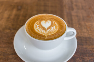 milk coffee in a cup on a wooden table
