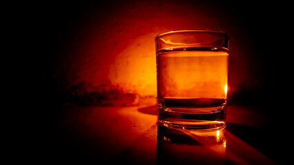 small round scented candle with a glass of vodka