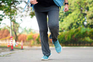 Sporty woman running on the road in the morning. Fitness and workout wellness concept.