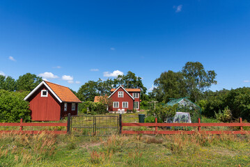 Fototapeta na wymiar Red wooden houses in the vollage Dörby, island of Öland, Sweden