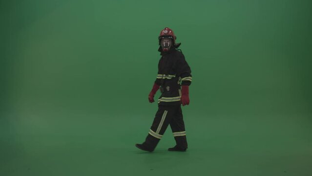 Young firefighter wearing fireman kit costume walking and watching around to notice something on green screen wall background