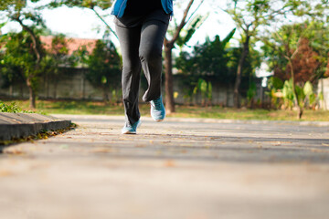 Sporty woman running on the road in the morning. Fitness and workout wellness concept.