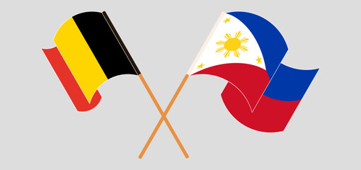 Crossed and waving flags of Belgium and the Philippines