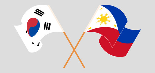 Crossed and waving flags of South Korea and the Philippines