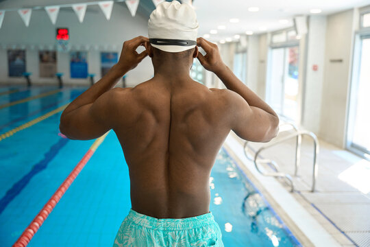 Swimmer putting on protective eyewear before swimming in pool