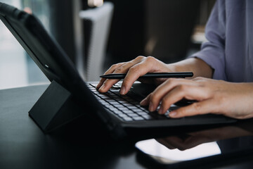 Asian Business woman using calculator and laptop for doing math finance on an office desk, tax, report, accounting, statistics, and analytical research concept