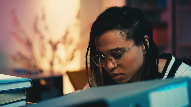 Exhausted student in glasses preparing for exams at night, too much studying