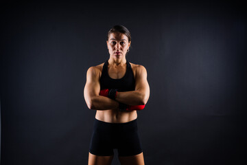 Fototapeta na wymiar Fitness woman with the red boxing bandages and gloves, studio shot