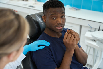 Scared male patient asking female doctor not to hurt him