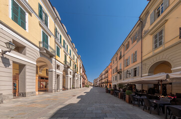 Fototapeta na wymiar Cuneo, Piedmont, Italy - Cityscape on Via Roma main pedestrian cobblestone street with Ancient buildings decorated and with arcade in historic center