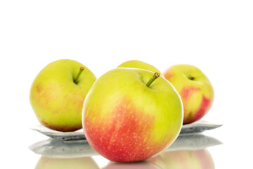Several organic juicy apples with light ceramic plate, macro, isolated on white background.