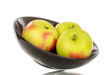 Three sweet juicy apples in a black ceramic plate, macro, isolated on white background.