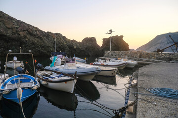 Fototapeta na wymiar boats in the harbor of Framura, Liguria, Italy during sunset sky across cliffs