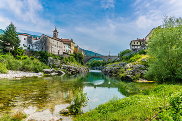 A view along the Soca river towards the bridge and the town of Kanal in Slovenia in summertime