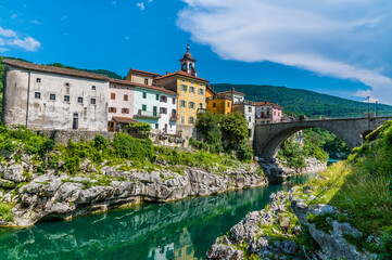 Fototapeta na wymiar A view along the Soca river towards the bridge and the town of Kanal in Slovenia in summertime