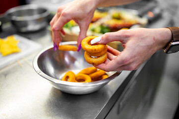 woman hand hold Onion rings on kitchen