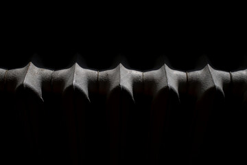 abstract silhouette of a radiator in a beam of light on a black background