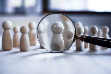 HRM or Human Resource Management, Magnifier glass focus to wooden people, manager, which is among...