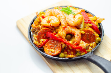 Delicious paella, cooked risotto rice with chicken thigh, king prawns, tomatoes and  chorizo - 636351917