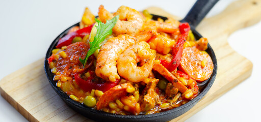 Delicious paella, cooked risotto rice with chicken thigh, king prawns, tomatoes and  chorizo