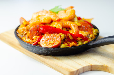 Delicious paella, cooked risotto rice with chicken thigh, king prawns, tomatoes and  chorizo