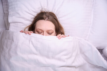 Close up of woman face covered with white blanket